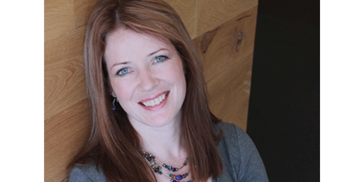 A headshot image of Kathryn Marsden smiling into the camera, you can see her from the shoulders up. 