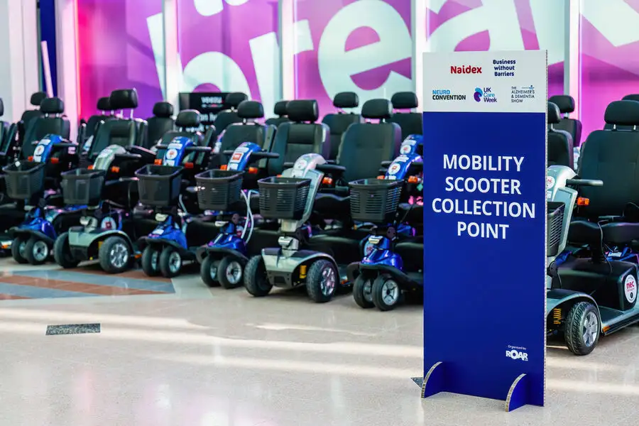 Mobility scooter collection point showing mobility scooters for hire at Naidex