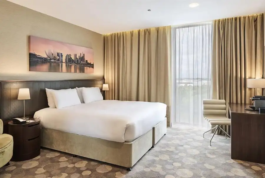 A modern hotel room with bed and ambient lighting