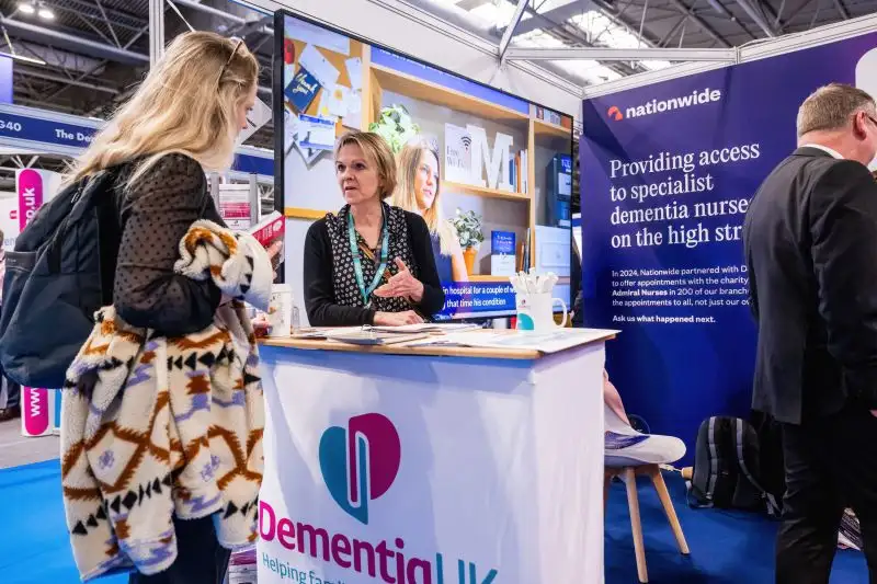 Two women discussing at Dementia UK exhibition stand