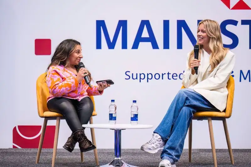 Two women seated and chatting on stage