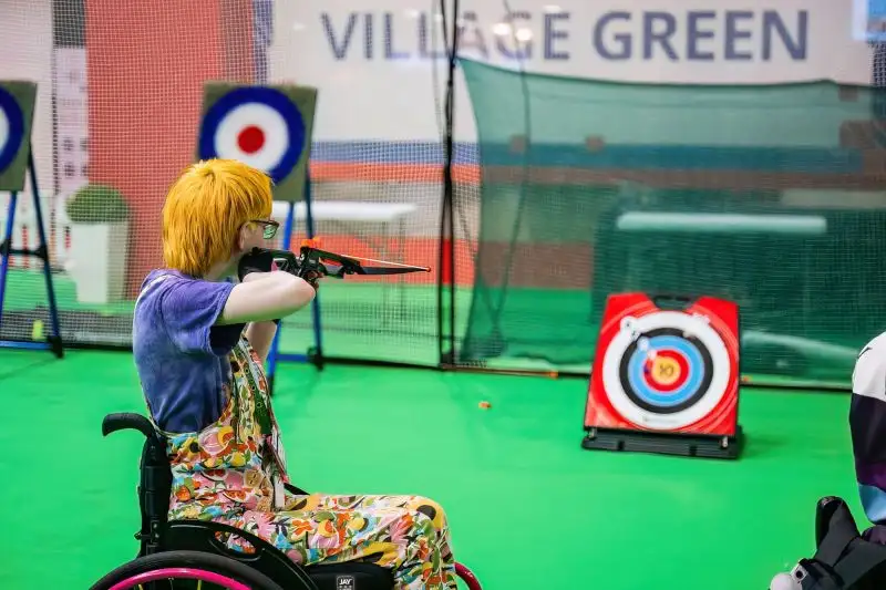 Person aiming with bow and arrow at target