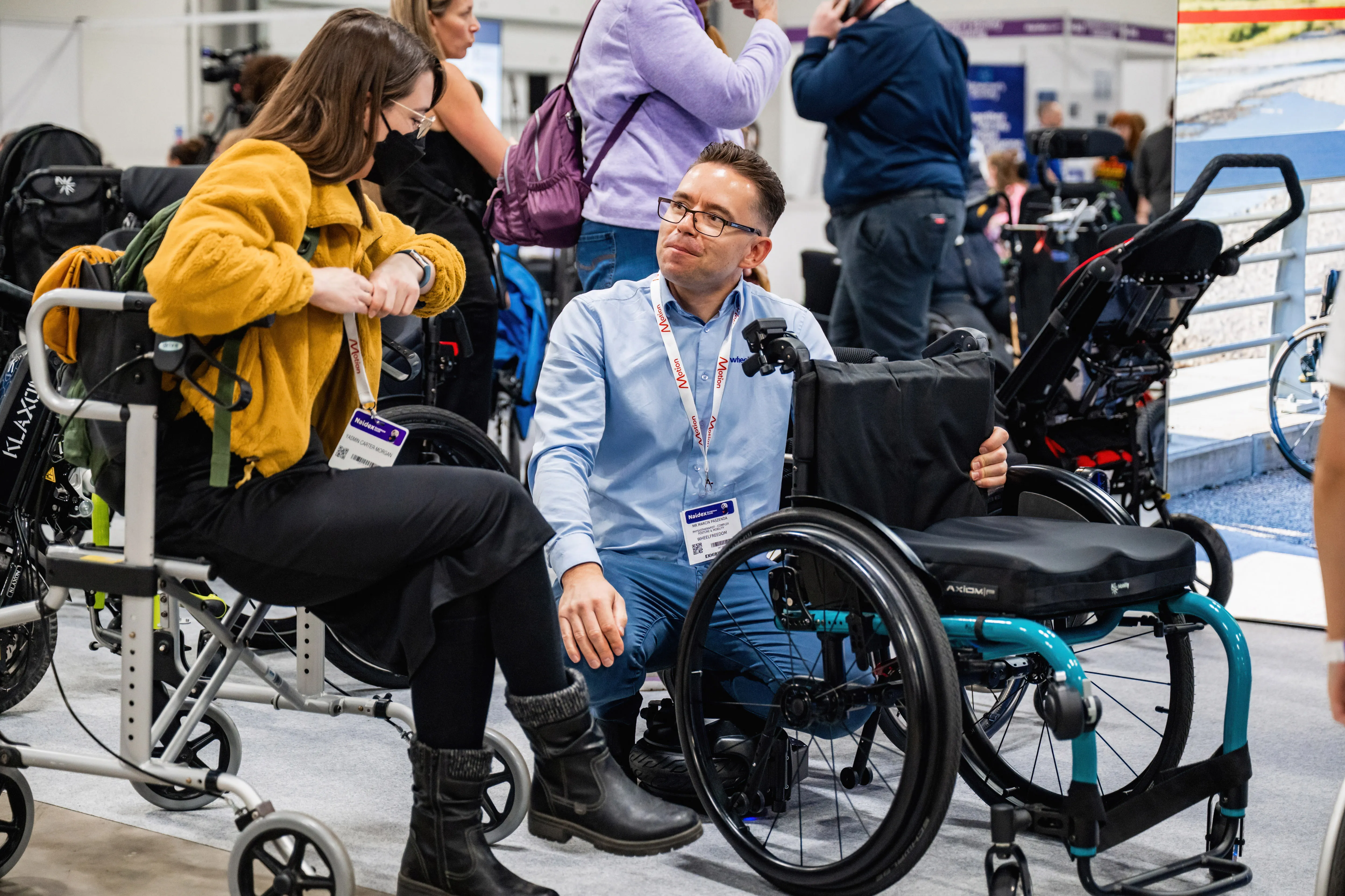 People walking through Naidex exhibition hall