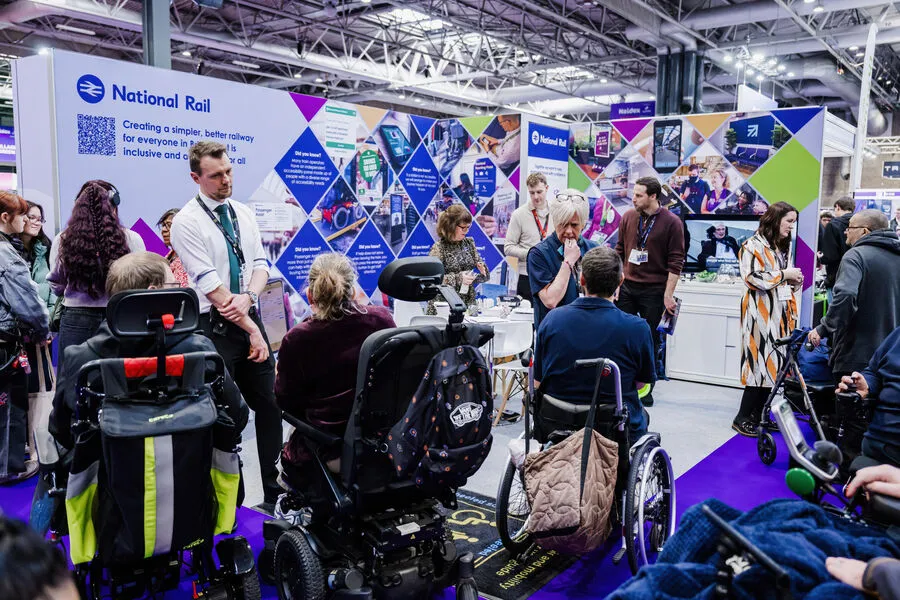 People walking through Naidex exhibition hall
