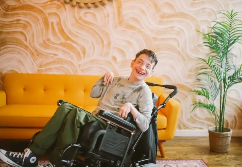 Picture of a young person in a wheelchair smiling